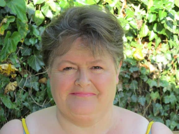 picture of Sharon Rowe standing in front of a green hedge