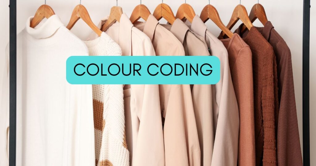 clothes hung up in colour order with the words colour coding on top.