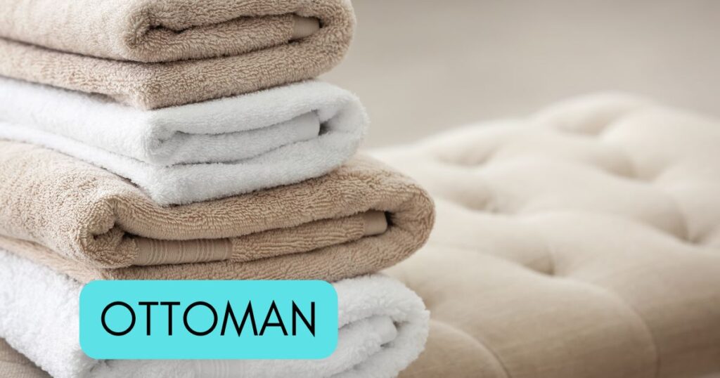 pile of towels on an ottoman.